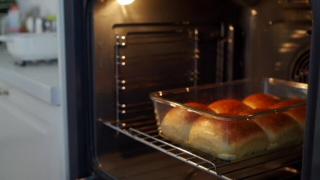 Homemade round-shaped soft buns dinner rolls baked in an oven. High quality 4k footage