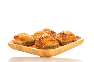 Sweet baklava classic on a bamboo tray, macro, isolated on a white background.
