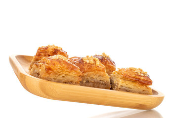 Sweet baklava classic on a bamboo tray, macro, isolated on a white background.