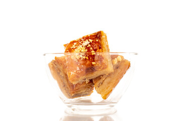 Sweet baklava classic with glassware, macro, isolated on white background.
