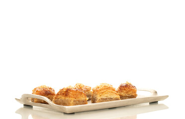 Sweet baklava classic on a metal tray, macro, isolated on a white background.