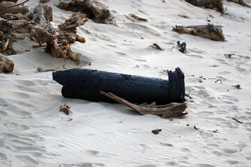 Zanieczyszczona plaża wyrzucone na brzeg odpady plastikowe duża gumowa rura plastikowy przewód - obrazy, fototapety, plakaty