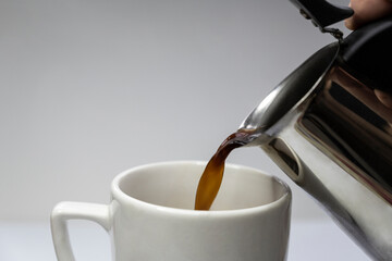 Pour hot coffee into a mug. Freshly brewed coffee