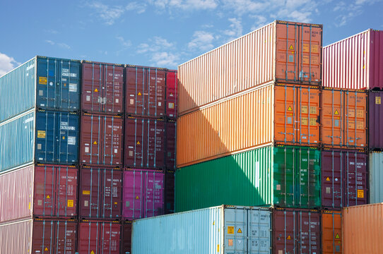 Shipping containers stacked against blue sky