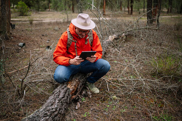 Man using a tablet in the forest.