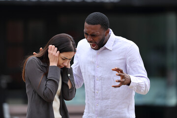 Angry man scolding and shouting to a scared woman