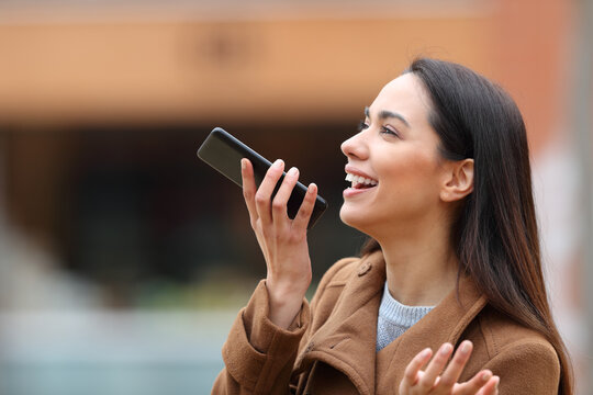 Woman Dictating Text On Phone In The Street In Winter