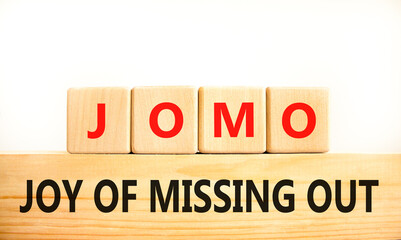 JOMO joy of missing out symbol. Concept words JOMO joy of missing out on wooden blocks on a beautiful white background. Business JOMO joy of missing out concept. Copy space.