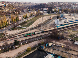 An old locomotive at a small railway station. Autumn city. Ships at the pier.