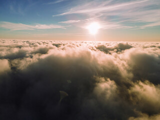 A magical sunset over the clouds. The rays of the sun beautifully pass through the clouds. Above the sky. Fluffy clouds at sunset thickly covered the sky. shooting at high altitude.