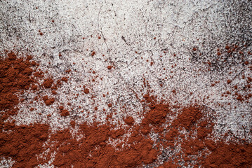 natural cocoa powder for chocolate and drinks scattered on a gray neutral concrete background