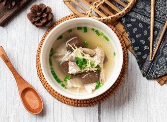 Powder sausage soup in a bowl with wooden spoon isolated on wood table side view taiwan food