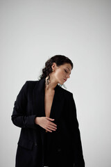 sexy young woman in a jacket on a naked body. Beautiful woman with wet hair in business clothes on a white background.