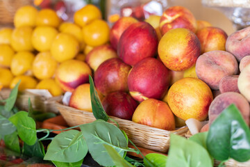 Peaches and yellow plums on the market. Selective focus.