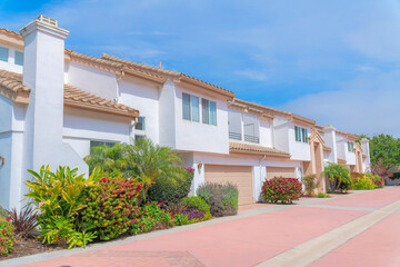 Fototapeta na wymiar White townhouses exterior with landscape garden at the front at Carlsbad, San Diego, California