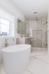 Fototapeta na wymiar Contemporary Luxury En Suite Bathroom. Modern bathroom design with free standing soaking tub, vanity, and glass enclosed shower with waterfall showerhead.