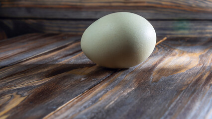 Araucana egg on wooden background. Light blue egg from Araucana chicken. Easter Festival concepts. Easter egg.