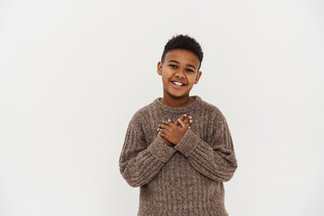 Black preteen boy smiling and holding hands on his chest © Drobot Dean