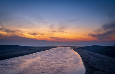 Fototapeta Wieczór nad morzem, plaża, woda wpływająca. Piękne niebo oświetlone resztkami słońca. obraz
