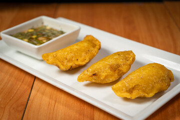 Colombian empanada with spicy sauce