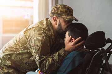 military soldier father kisses his disabled son. happy with autism indoors, kissing her cheek.