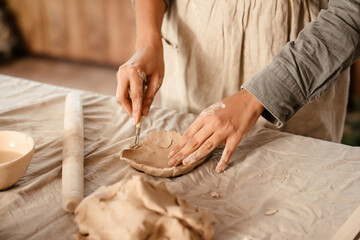 Obraz na płótnie Canvas Young black ceramist woman sculpting in clay at her workshop