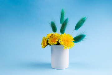 Glory to Ukraine. Yellow flowers on a blue background. Dandelions. Minimal conceptual idea. The colors of the Ukrainian flag. Space for text