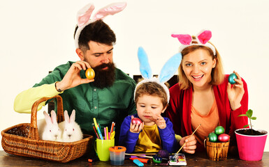 Easter Family traditions. Happy father, mother and son in bunny ears with painted decorated eggs.