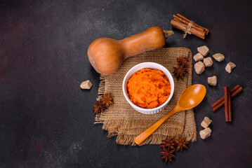 Pumpkin carrot baby puree in bowl on a dark background