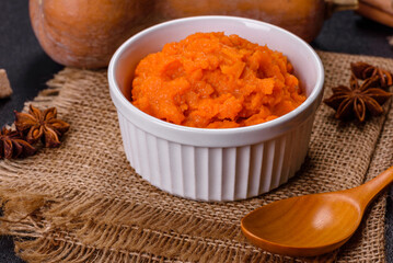 Pumpkin carrot baby puree in bowl on a dark background