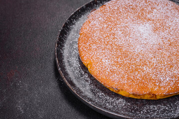 Pumpkin pie, tart made for Thanksgiving day with whipped cream on a black plate