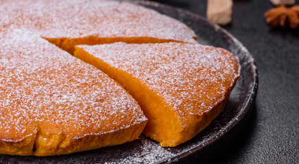 Pumpkin pie, tart made for Thanksgiving day with whipped cream on a black plate
