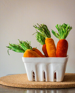 fake plush carrots in a vegetable basket