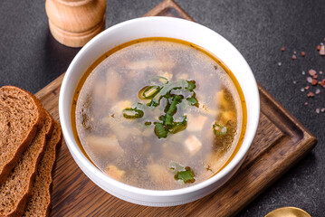 Delicious healthy soup with sorrel, tomato, potatoes, spices and herbs in a white bowl