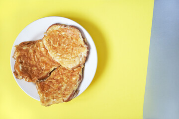 Delicious egg sandwiches in a plate on a yellow background with a silver insert. A hot homemade sandwich with a place to copy.