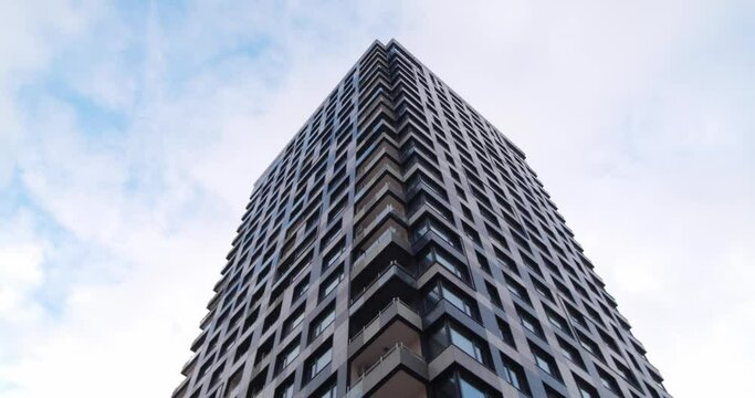 Skyscraper Against Cloudy Sky, Low Angle View. Camera Panning Right