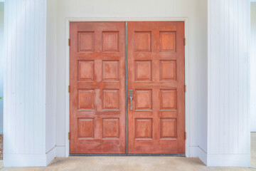 Fototapeta premium Wooden double doors against the white walls of a house at Carlsbad, San Diego, California