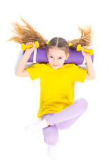 Little cute happy girl lies with dumbbells and gymnastic mat. Isolated on white background. View from above.