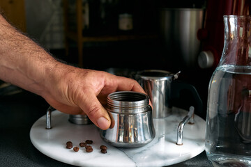 Man prepare classic Italian coffee in the moka pot in the kitchen. Coffee brake. Morning habit.