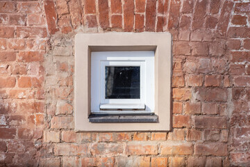 A small square window in a brick wall.