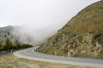mountain landscape with a dangerous road bend in the fog