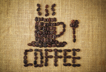 Coffee cup with words coffee made of  coffee beans on burlap sack. top view. Agriculture, coffee shop concept.                           