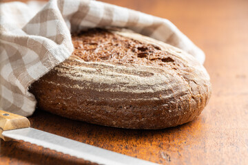 Loaf of bread on wooden table.