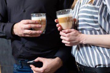 Close-up. man and woman drinking latte coffee.
