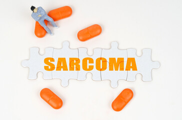 On the white surface of the tablet, a miniature human figure and puzzles with the inscription - SARCOMA