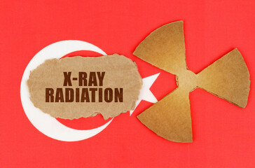 On the flag of Turkey, the symbol of radioactivity and torn cardboard with the inscription - X-Ray Radiation