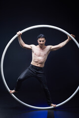  Circus performer artist with muscles body in a Cyr Wheel (Roy Cyr) isolated at  black background