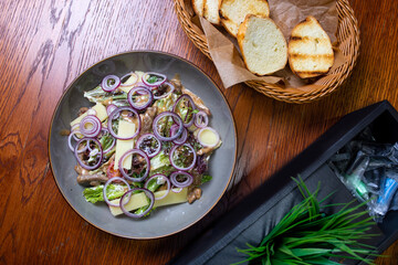 Salad with hard cheese, onions and herbs on a plate. Healthy and tasty food.