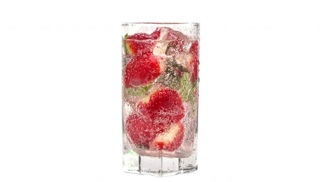 Fresh appetizing carbonated cocktail strawberry mint ice with fizzy bubbles in glass slowmo isolated