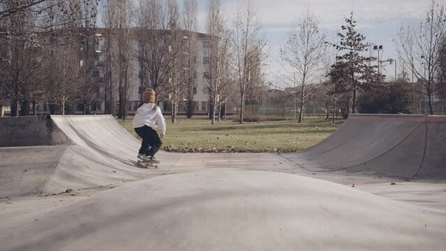 Skater su mini rampa in cemento, in un parco cittadino